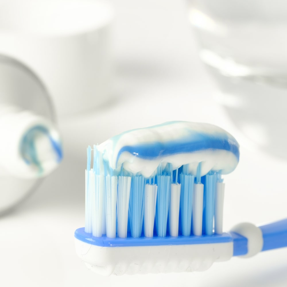 Zahnpasta mit Fluoriden und Zahnbürste